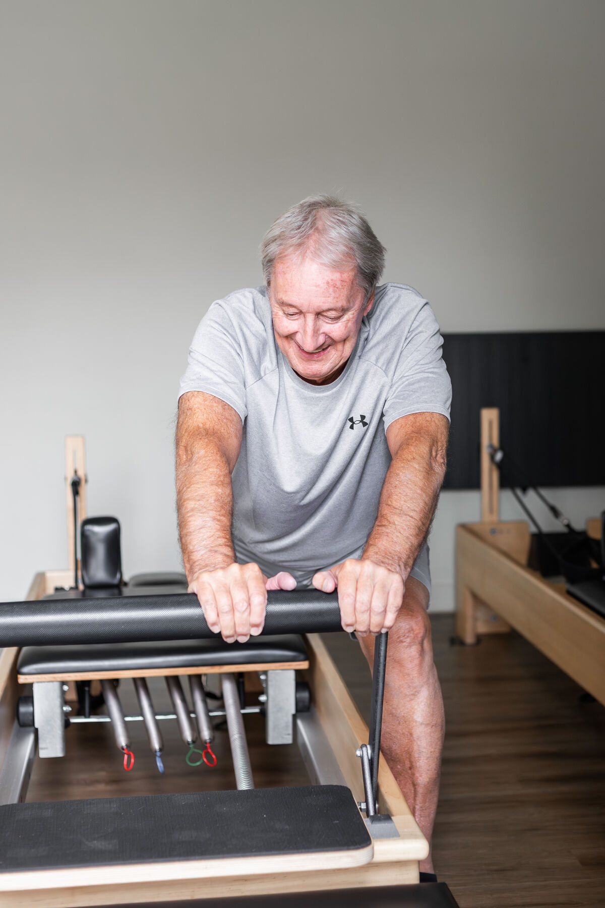 A smiling client working on the Reformer footbar